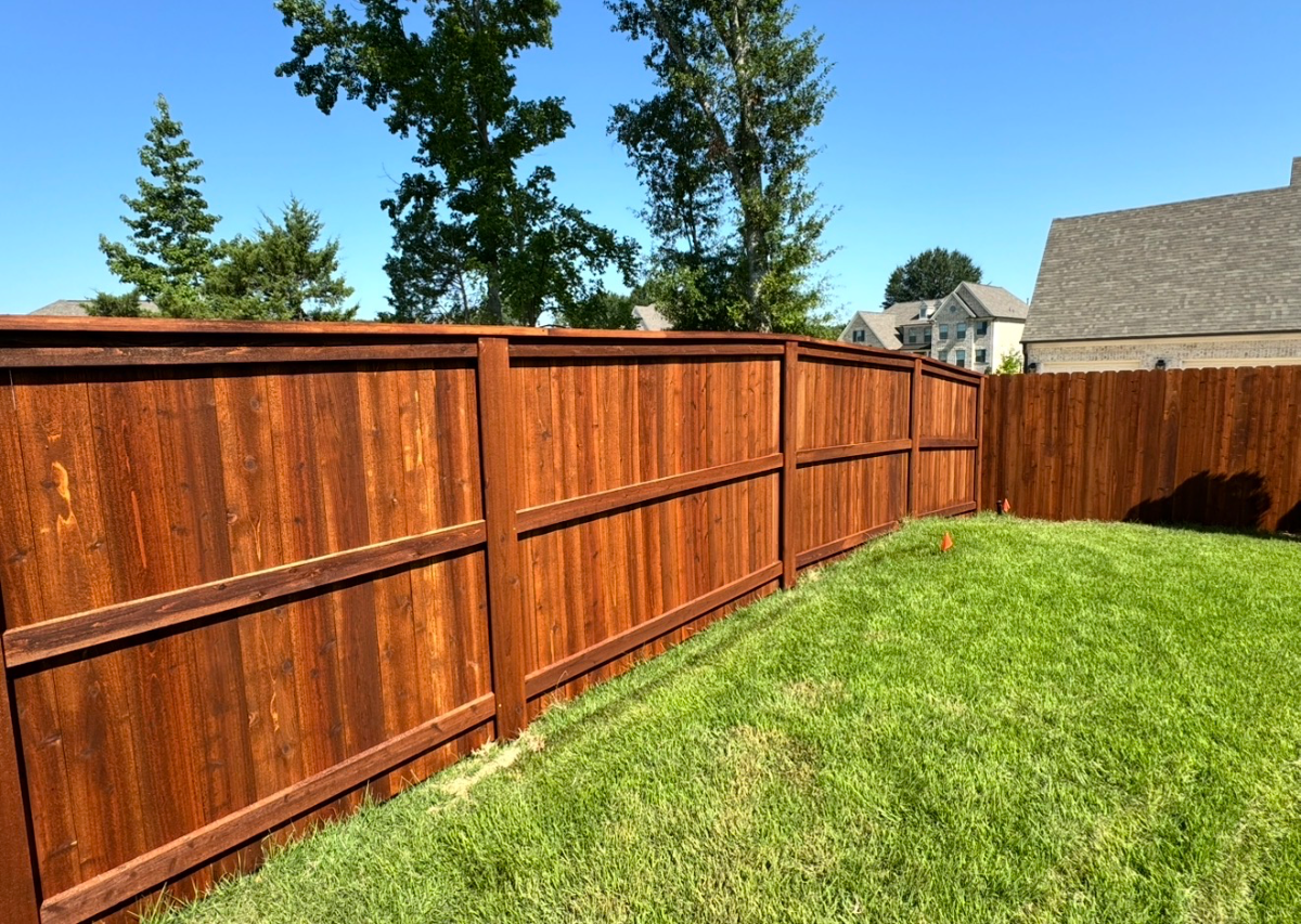 Cedar cap and trim fence along a residential backyard