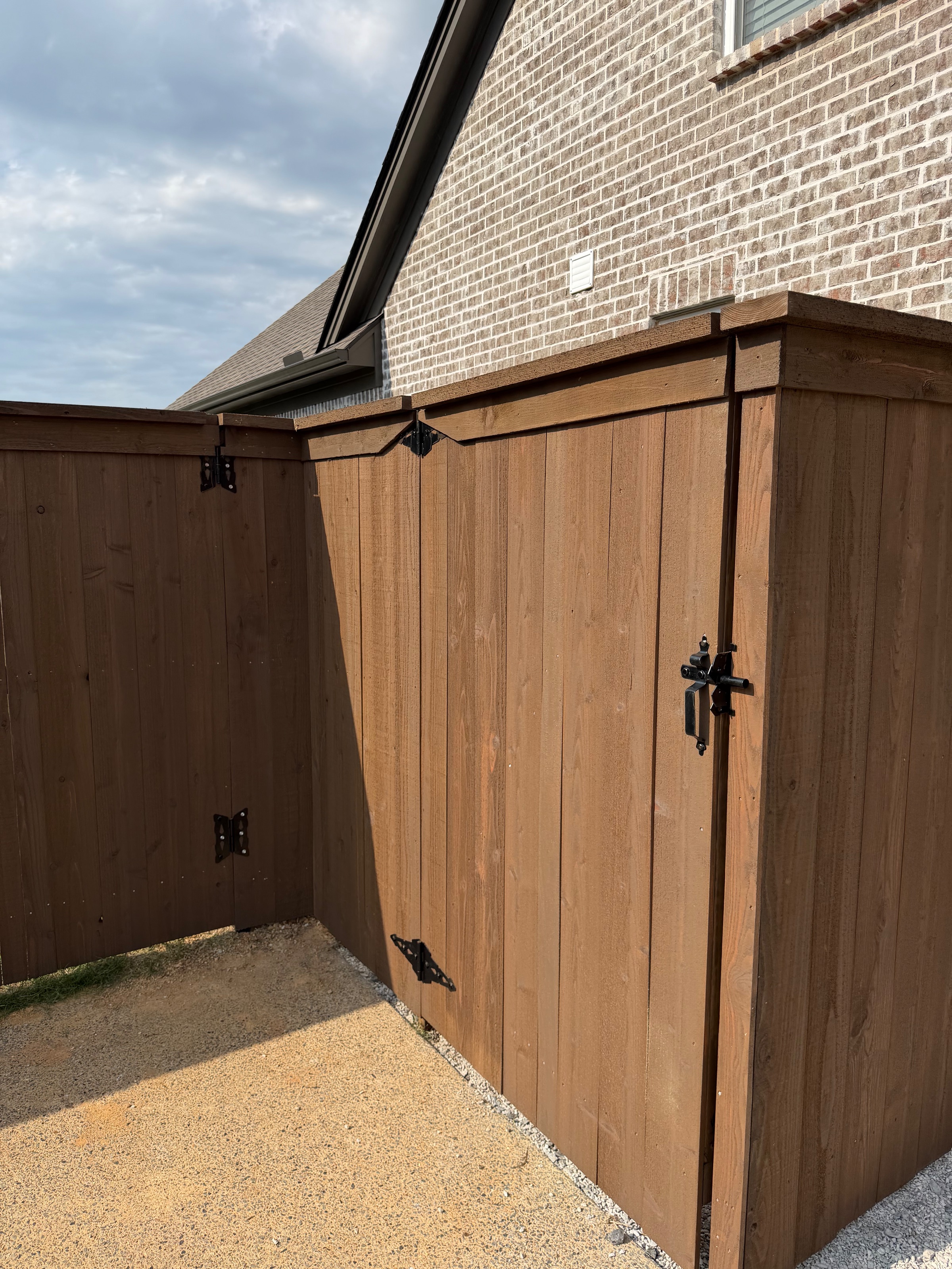 Long pre-stained cedar fence line along a wooded rear property boundary