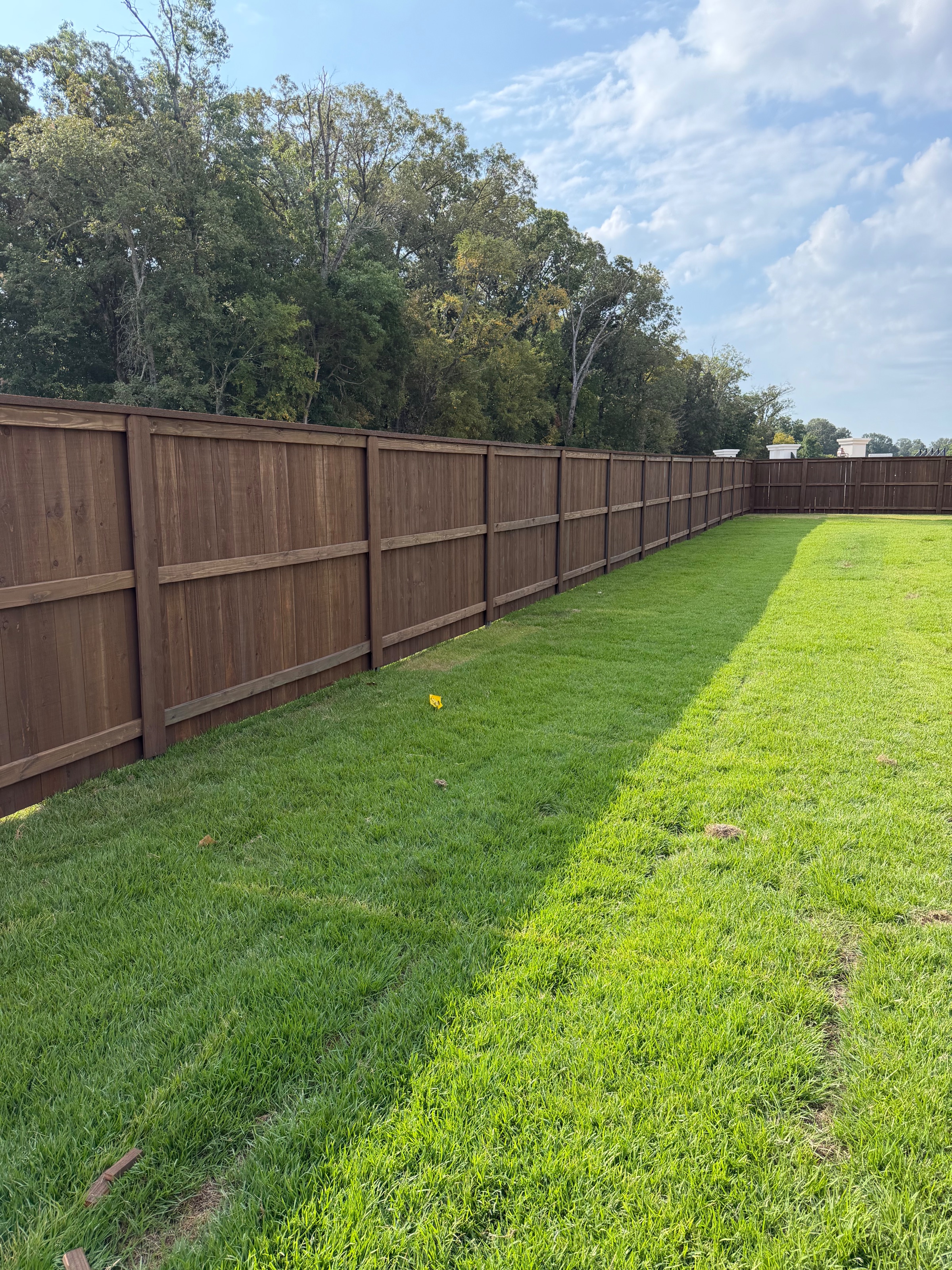 Cedar privacy gate and corner transition against a brick exterior wall