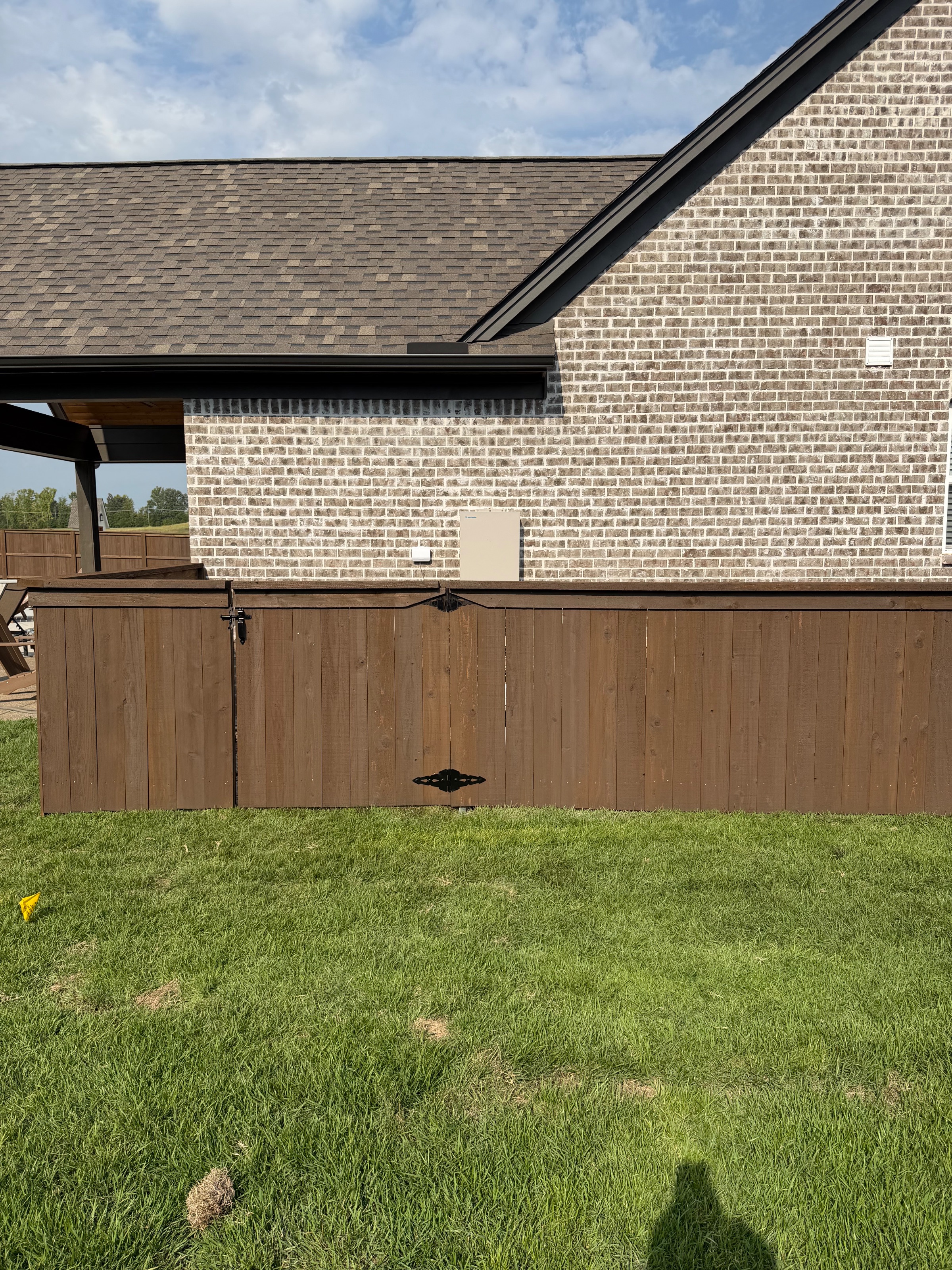 Pre-stained cedar fence returning to the house beside a covered patio