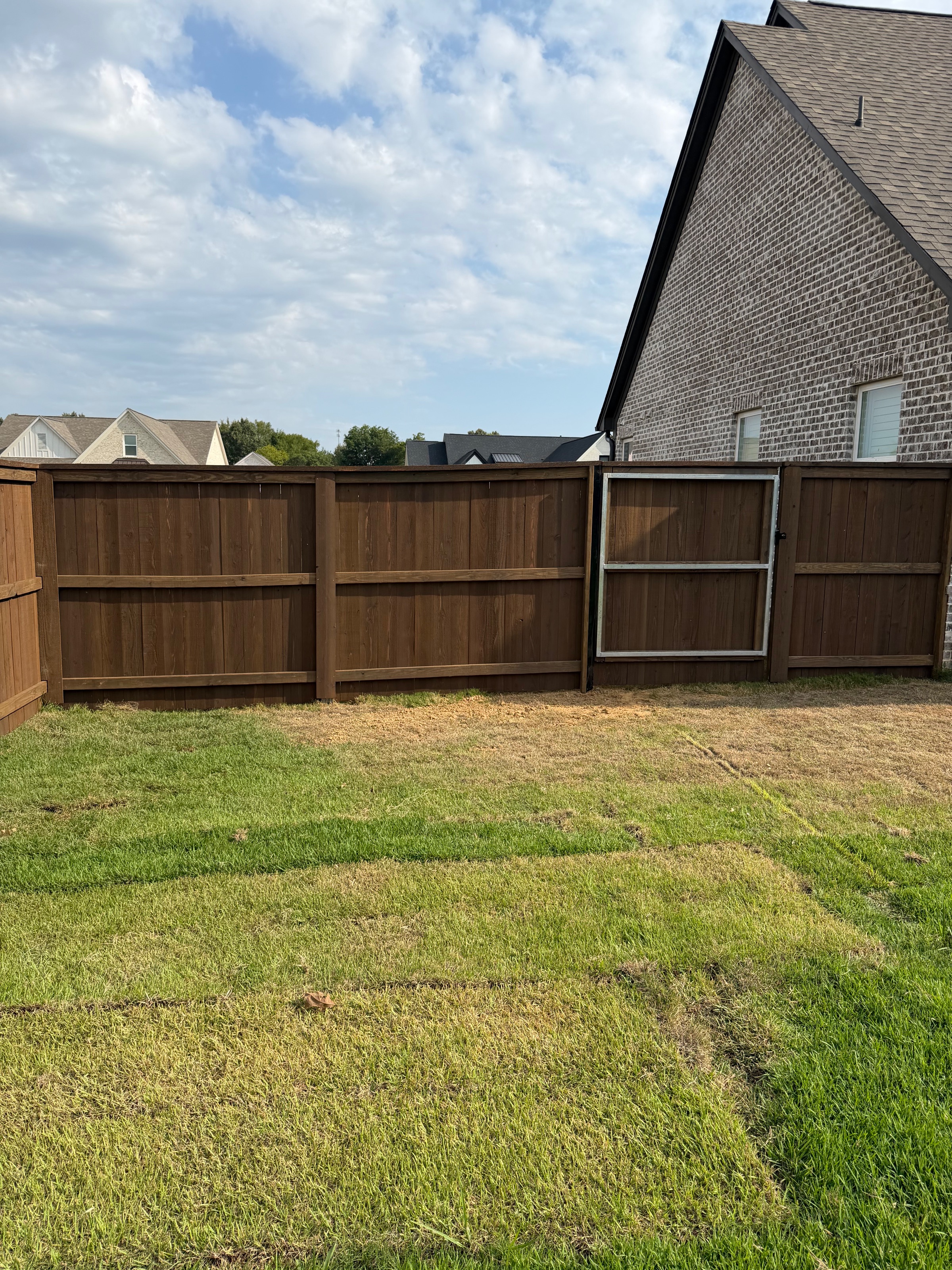 Metal-framed walk gate set into a pre-stained cedar privacy fence
