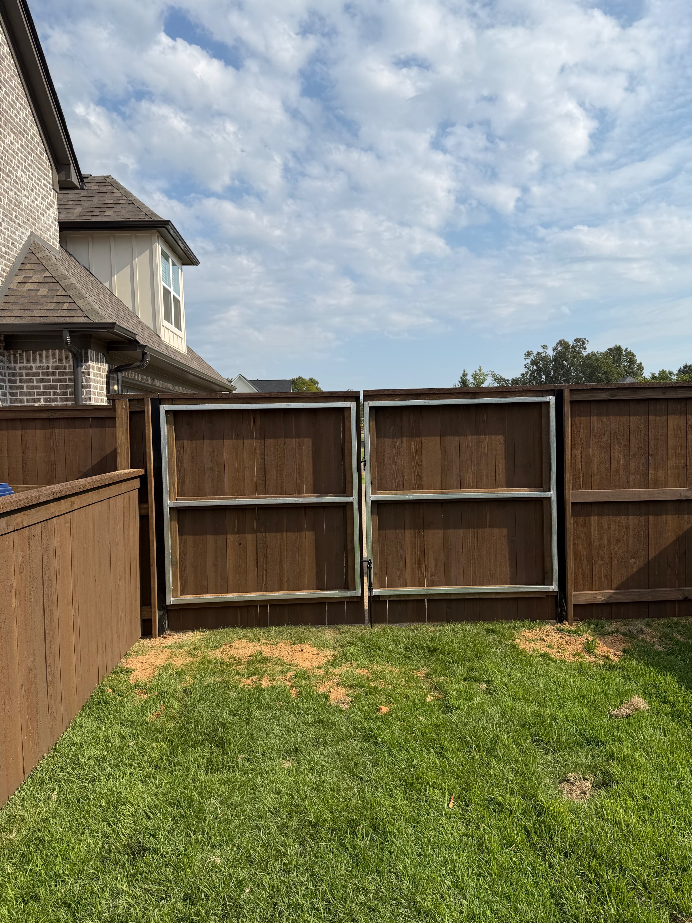Metal-framed double drive gate built into a pre-stained cedar privacy fence