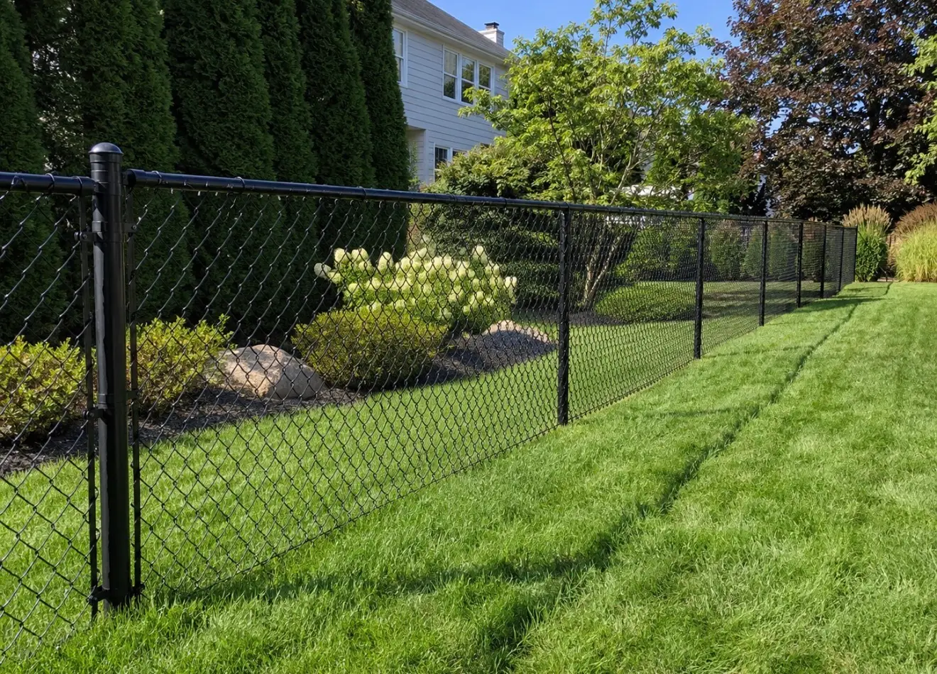 Black coated chain link fence enclosing a residential back yard